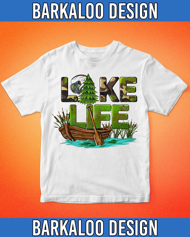 K&ouml;nnte beinhalten: Wei&szlig;es T-Shirt mit einem gr&uuml;nen Tarnmuster, auf dem "LAKE LIFE" steht, mit einem kleinen Baum und einem Boot mit Rudern im Wasser.