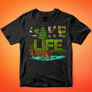 K&ouml;nnte beinhalten: Schwarzes T-Shirt mit einem gr&uuml;nen, braunen und wei&szlig;en Camouflage-Muster, auf dem "LAKE LIFE" steht. Das Design enth&auml;lt auch einen kleinen Kiefernbaum, eine Angelrute und ein Holzboot.