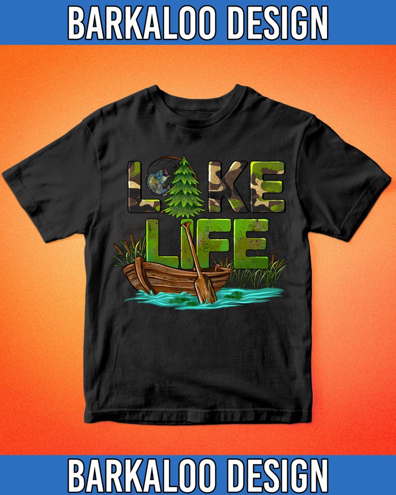 K&ouml;nnte beinhalten: Schwarzes T-Shirt mit einem gr&uuml;nen, braunen und wei&szlig;en Camouflage-Muster, auf dem "LAKE LIFE" steht. Das Design enth&auml;lt auch einen kleinen Kiefernbaum, eine Angelrute und ein Holzboot.