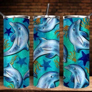 Puede incluir: Un vaso de acero inoxidable con un dise&ntilde;o turquesa y azul que presenta un patr&oacute;n repetido de delfines y estrellas de mar.