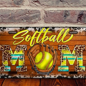 May include: A metal license plate with a wood grain background and a cowhide pattern border. The text "Softball Mom" is written in yellow with a leopard print "M". A yellow softball is in a brown leather glove.