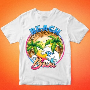 May include: White t-shirt with a graphic design of a beach scene with palm trees, waves, and the text "Beach Bum".