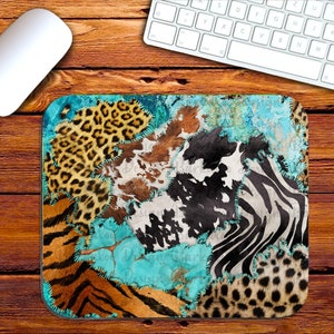 May include: A mouse pad with a patchwork design featuring various animal prints, including leopard, zebra, cowhide, and tiger. The background is a turquoise blue with a distressed look.