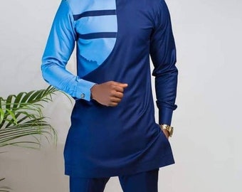 May include: A long-sleeved shirt with a blue and light blue color block design. The shirt has a round neckline and a geometric pattern on the left side.