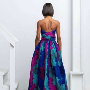May include: A strapless maxi dress with a blue, teal, and pink floral print. The dress has a fitted bodice and a flowing skirt.