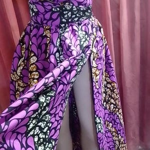 May include: A purple and black patterned maxi skirt with a high slit. The skirt has a floral design with white accents.