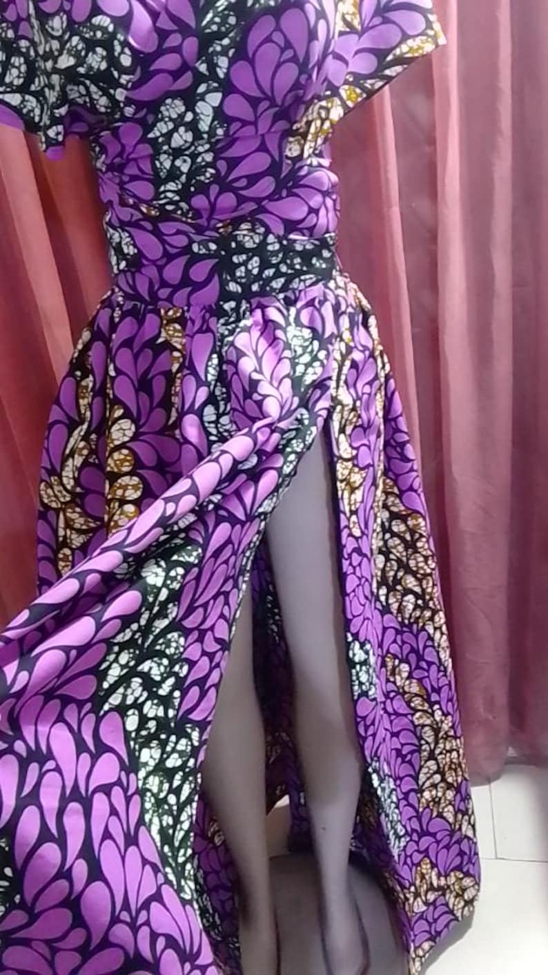 May include: A purple and black patterned maxi skirt with a high slit. The skirt has a floral design with white accents.