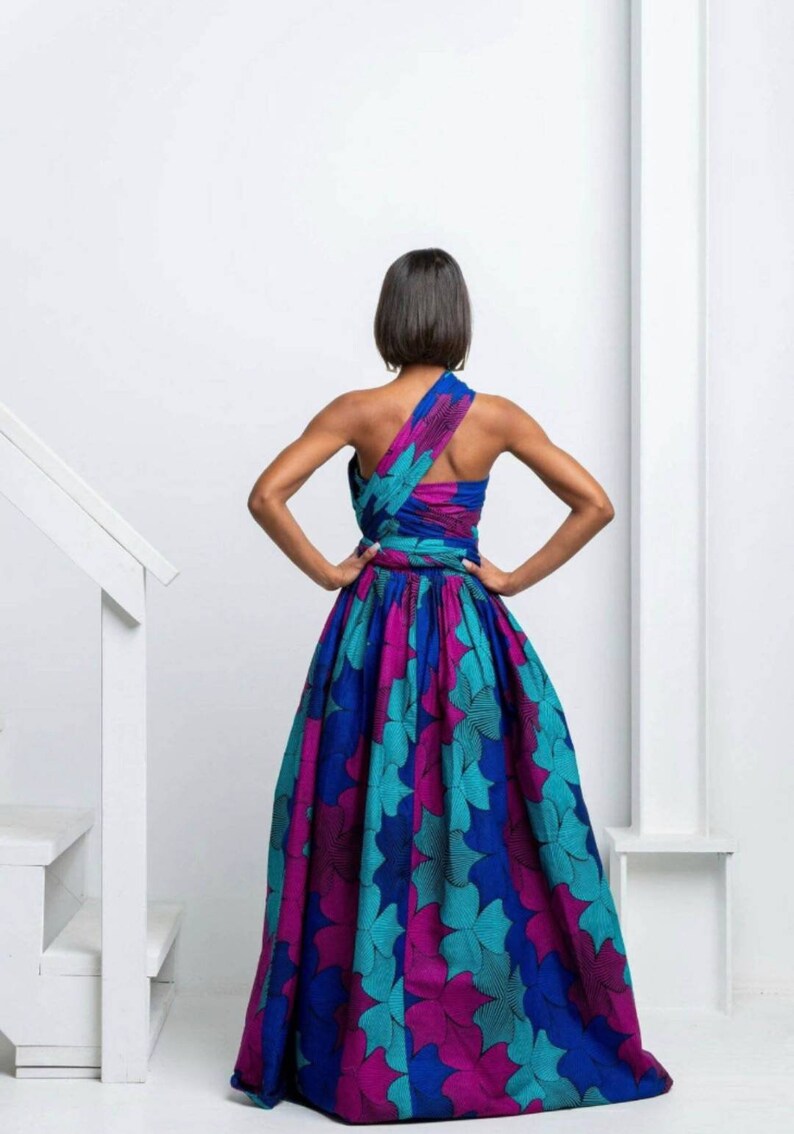 May include: A long, flowing dress with a one-shoulder design. The dress is made of a colorful fabric with a floral pattern in shades of blue, teal, pink, and purple.