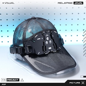 Puede incluir: Gorra de béisbol de malla negra con visera transparente y un dispositivo negro de aspecto futurista fijado en la parte delantera. El dispositivo tiene el texto "RXL D UNIT" y "2025" impreso. La gorra tiene un cierre de hebilla. También se ven las palabras "VISUAL" y "F-A PROJECT".