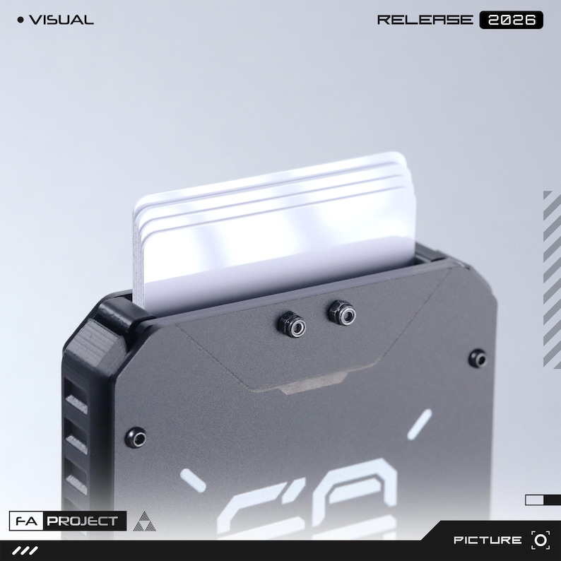 May include: A matte black metal card holder with a stack of white cards inserted at the top. The front features two small exposed screws and white graphic text. The top corners of the holder are angled, and the side has a textured grip pattern.