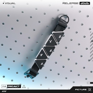 Puede incluir: Una pulsera en blanco y negro con segmentos triangulares y una correa negra. La pulsera tiene el texto "-1", "-2", "-3", "-4" y "-5" en los segmentos triangulares. La imagen también incluye el texto "VISUAL", "RELEASE 2025", "F-A PROJECT" y "PICTURE".