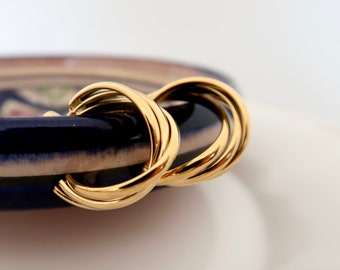 Guldfärgade, vridna örhängen i rostfritt stål