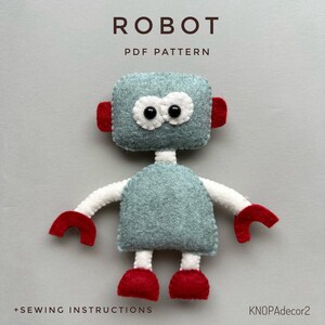 May include: A PDF pattern for sewing a felt robot toy. The robot is gray with white arms and legs, red hands and feet, and black eyes. The pattern includes sewing instructions.