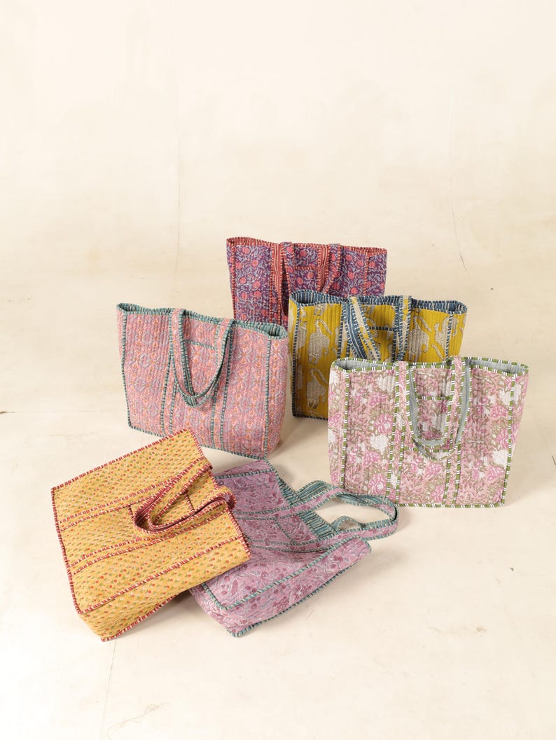 May include: Six colorful tote bags with different patterns and designs. The bags are made of quilted fabric and have a variety of colors, including pink, yellow, blue, and green.