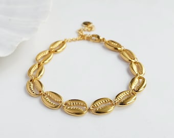 Puede incluir: Pulsera dorada hecha de abalorios en forma de concha unidos.