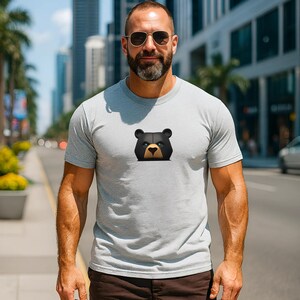 Unleash your strength with this sport grey shirt featuring a fierce black bear with piercing blue eyes. Perfect for gay bear lovers, this bear pride shirt for men is the ultimate pride outfit, combining bold style with powerful representation. Get yours today and unleash your inner woof.