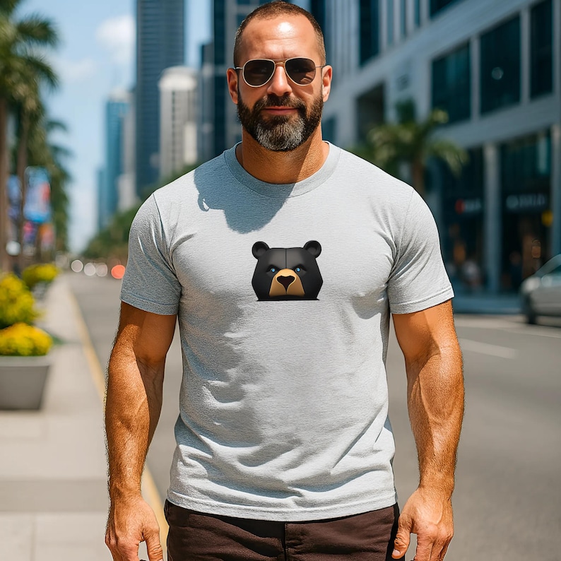 Unleash your strength with this sport grey shirt featuring a fierce black bear with piercing blue eyes. Perfect for gay bear lovers, this bear pride shirt for men is the ultimate pride outfit, combining bold style with powerful representation. Get yours today and unleash your inner woof.