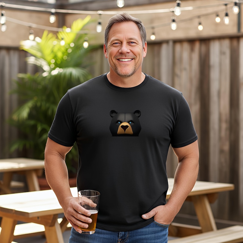 This handsome daddy is wearing a black muscle bear t shirt featuring a fierce black bear with electric blue eyes.  This is the perfect gay daddy shirt for your woof worthy gay bear on your gift list this season.