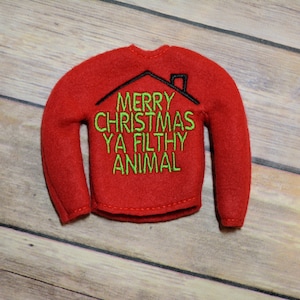Peut inclure: Pull-over rouge en feutre de taille d'elfe avec une broderie noire et verte qui dit "Joyeux Noël Ya Filthy Animal".