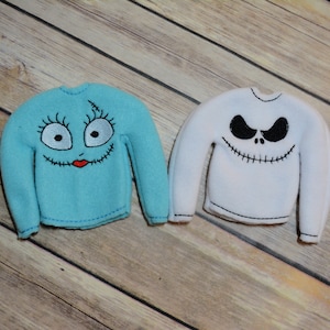 Peut inclure: Deux pulls de taille d'elfe, un bleu avec un visage de Sally cousu et un blanc avec un visage de Jack Skellington cousu.