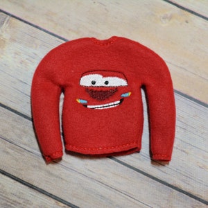 Peut inclure: Pull en polaire rouge pour lutin avec une image brodée de Flash McQueen du film Cars de Disney Pixar.