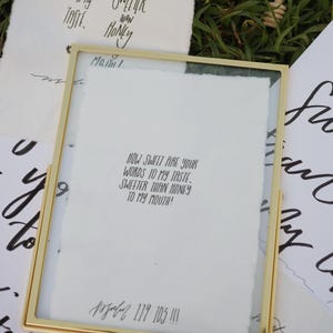 Puede incluir: Una obra de arte con marco dorado con texto manuscrito sobre papel blanco. El texto dice: "¡Qué dulces son tus palabras a mi gusto, más dulces que la miel a mi boca!" Hay otras notas manuscritas en el fondo.
