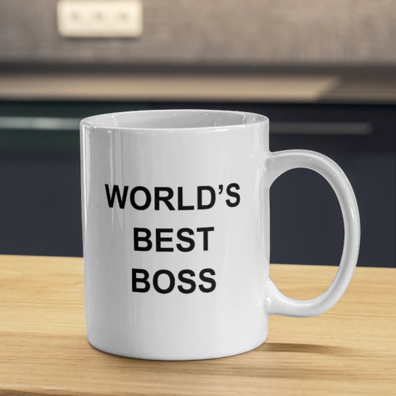 May include: White ceramic coffee mug with black text that reads "WORLD'S BEST BOSS".