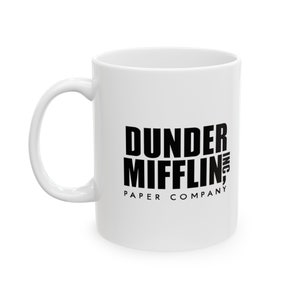 May include: White ceramic mug with a black graphic of the text "Dunder Mifflin, Inc. Paper Company"