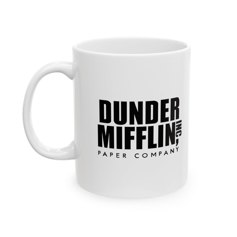 May include: White ceramic mug with a black graphic of the text "Dunder Mifflin, Inc. Paper Company"