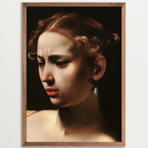 Altered art print of the baroque painting Judith beheading Holofernes by Caravaggio. The print shows only her face, with a mix of determination and disgust. The deep line between her eyebrows shows effort and concentration, revealing her female rage.