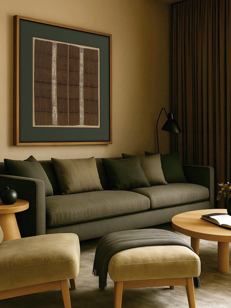 Large vintage textile wall art print with brown and cream woven patterns, displayed above a dark olive green sofa in a modern living room.