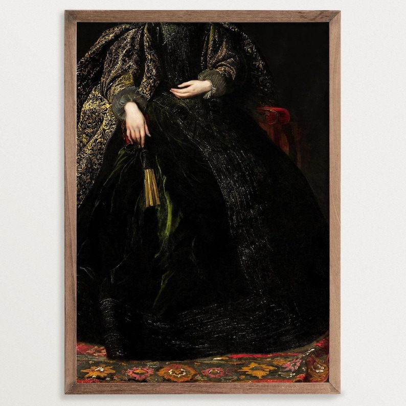 A framed art print depicting the lower half of a seated woman in a richly detailed black and gold embroidered gown. Her hands rest on her lap, holding a tassel. The frame is made of wood, enhancing the classic aesthetic of the artwork