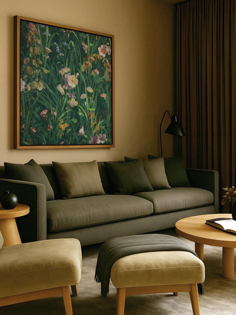 Botanical wall art featuring vibrant meadow flowers, hanging above a dark green sofa in a cozy living room with earthy tones and soft lighting.