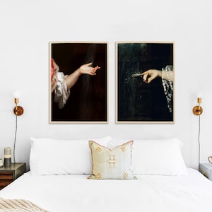 K&ouml;nnte beinhalten: Zwei gerahmte Kunstdrucke mit klassischen Gem&auml;lden von H&auml;nden. Einer zeigt eine ausgestreckte Hand, der andere eine zeigende Hand. Die Drucke haben dunkle Hintergr&uuml;nde und werden &uuml;ber einem Bett ausgestellt.