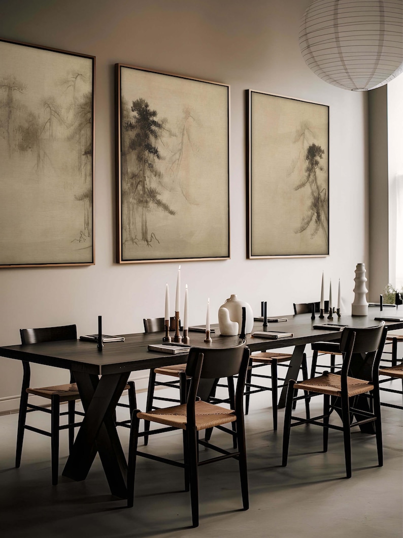 Set of three framed Japanese sumi-e ink paintings featuring misty pine trees, displayed in a modern dining room with dark wood furniture and minimalist Japandi decor. The soft, earthy tones create a tranquil and elegant atmosphere.