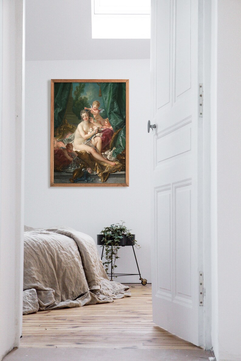 May include: A framed painting of a woman in a white dress with two cherubs. The woman is sitting on a couch with a green and gold background. The painting is in a wooden frame.