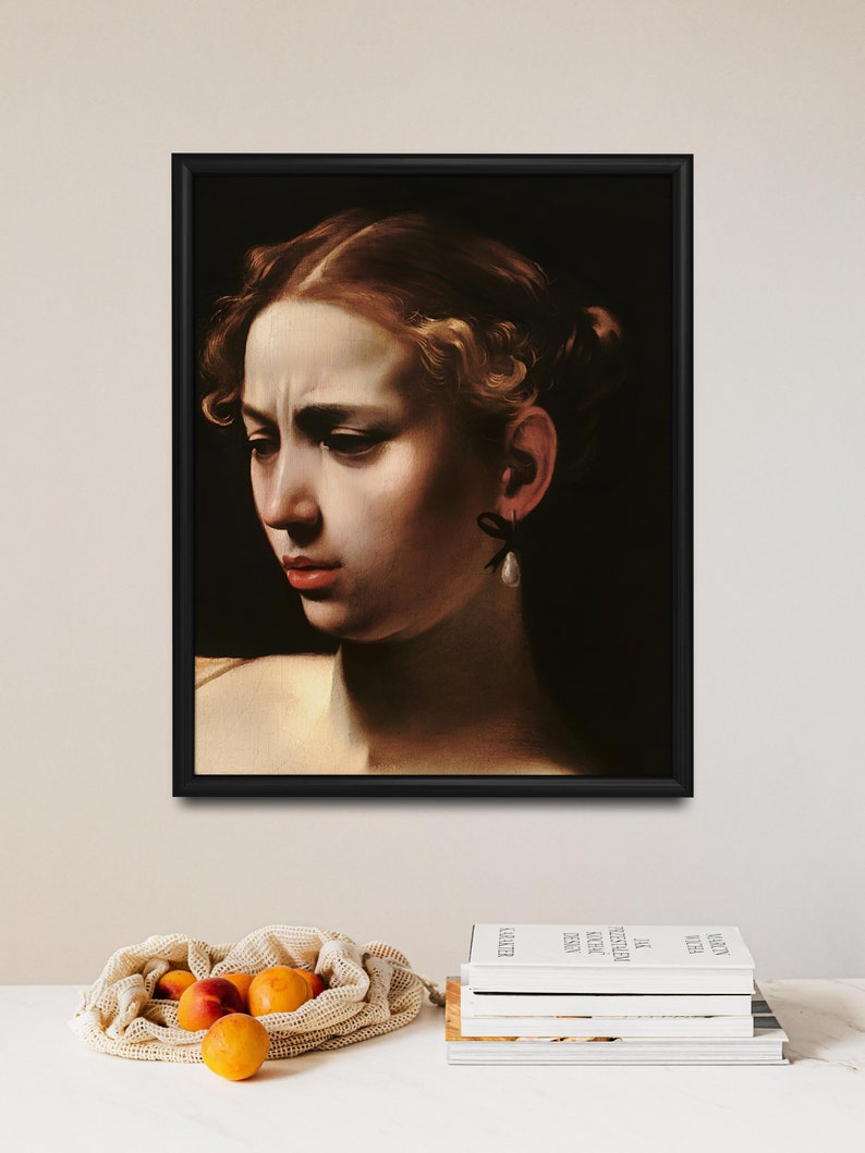 May include: A framed painting of a woman's face. The woman has light brown hair and is wearing a pearl earring. The painting is set against a dark background.