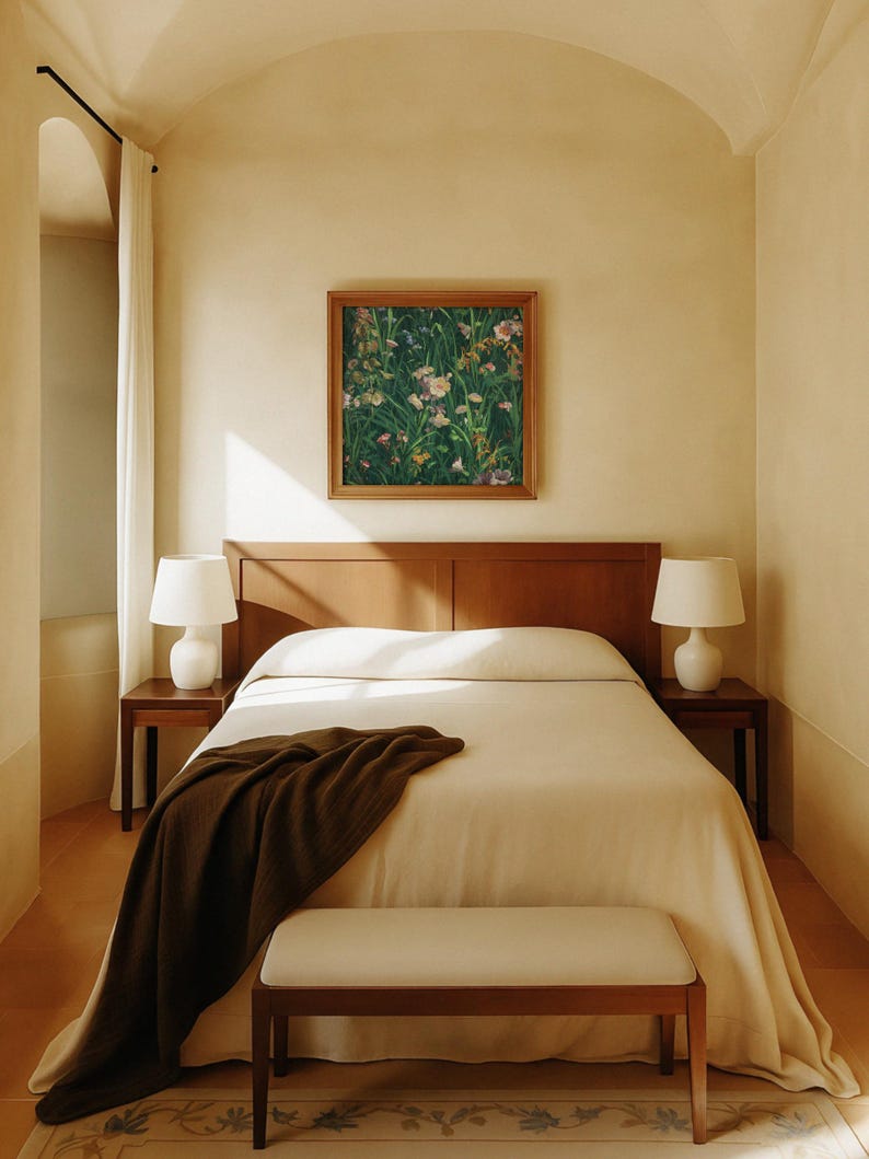Framed wildflower meadow painting hanging above a wooden bed in a serene, minimalist bedroom with warm beige walls, white bedding, and soft natural light.