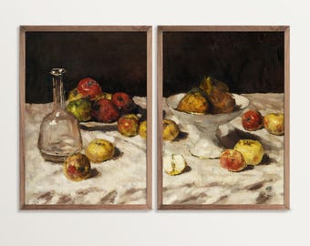 May include: Two framed still life paintings. One features a clear glass bottle and a plate of apples. The other shows a white bowl filled with pears and apples. Both paintings have a dark background and a white tablecloth.