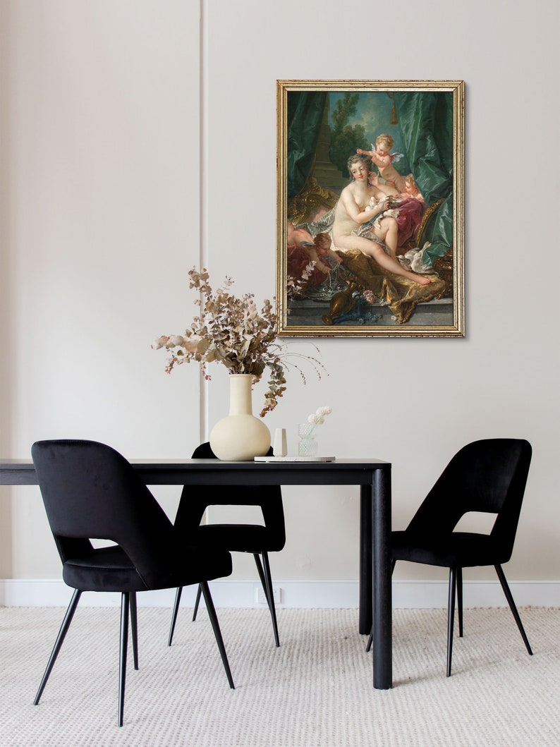 May include: A framed oil painting depicting a woman reclining on a chaise lounge with two cherubs. The woman is nude and has long, flowing hair. The cherubs are dressed in white and are holding flowers. The painting is set in a garden with a fountain in the background.