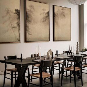 Triptych of wabi-sabi-inspired canvas wall art featuring serene, misty pine trees in earthy tones, elegantly framed and displayed in a modern dining room with minimal decor.