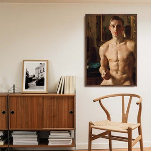 Puede incluir: Una pintura enmarcada de un hombre desnudo de pie en una habitaci&oacute;n con un espejo detr&aacute;s de &eacute;l. El hombre est&aacute; mirando directamente al espectador. La pintura est&aacute; en un marco marr&oacute;n y est&aacute; colgada en una pared blanca.