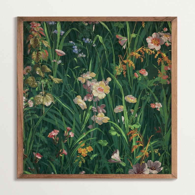 Framed square wildflower meadow art print with lush green grass and colorful blossoms, shown against a light wall for a clean product view.