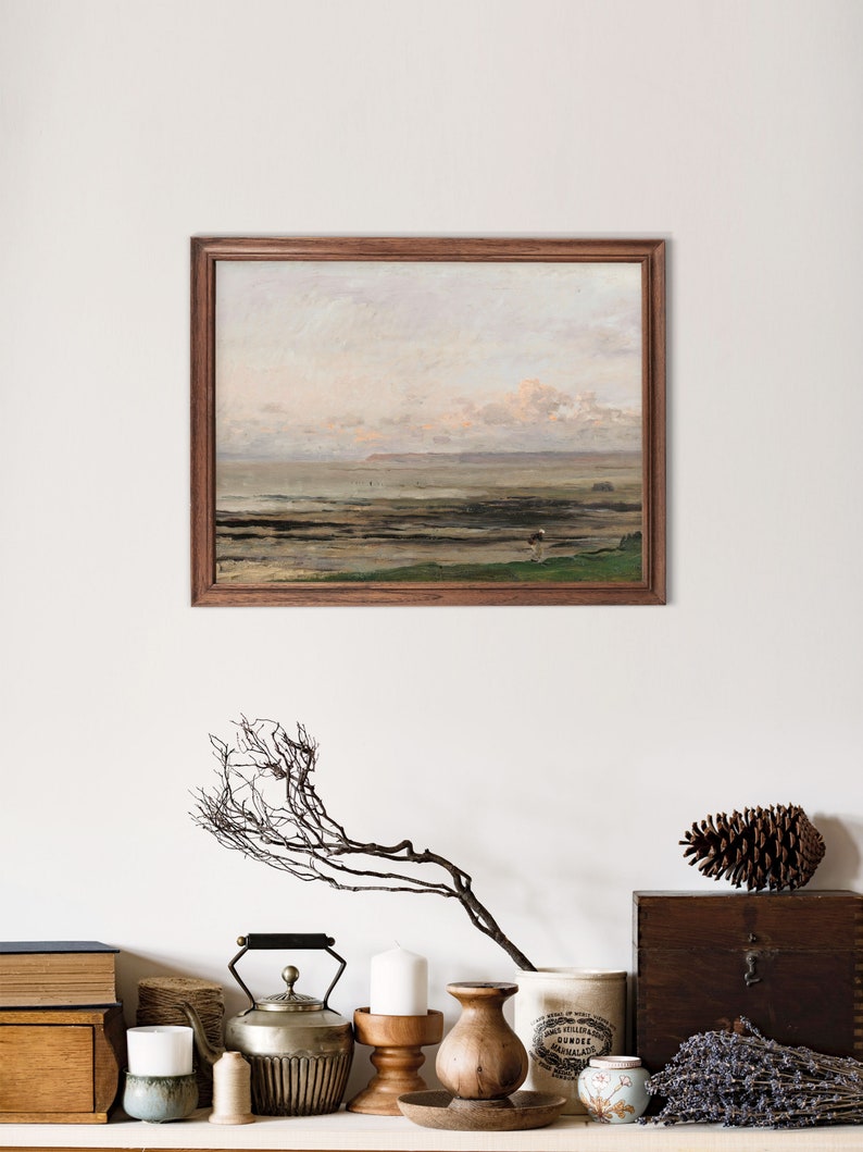 May include: A framed painting of a seascape with a cloudy sky and a distant shoreline. The painting is in a wooden frame and is hanging on a white wall.