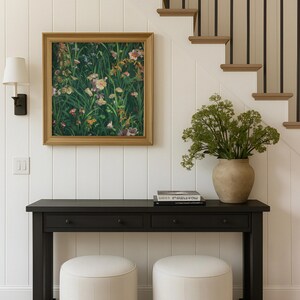 Vintage wildflower art print hanging in a modern cottage-style hallway under a staircase, styled with a dark console table and a ceramic vase.