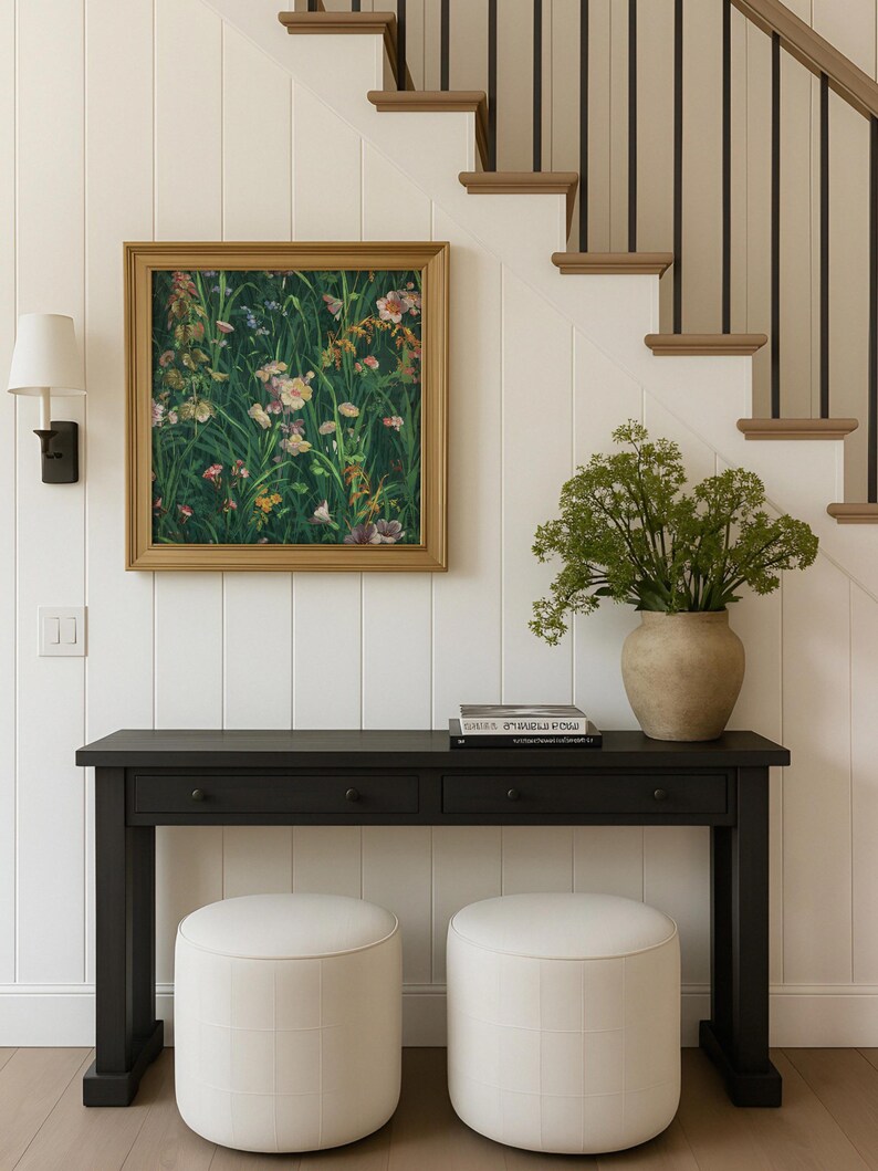 Vintage wildflower art print hanging in a modern cottage-style hallway under a staircase, styled with a dark console table and a ceramic vase.