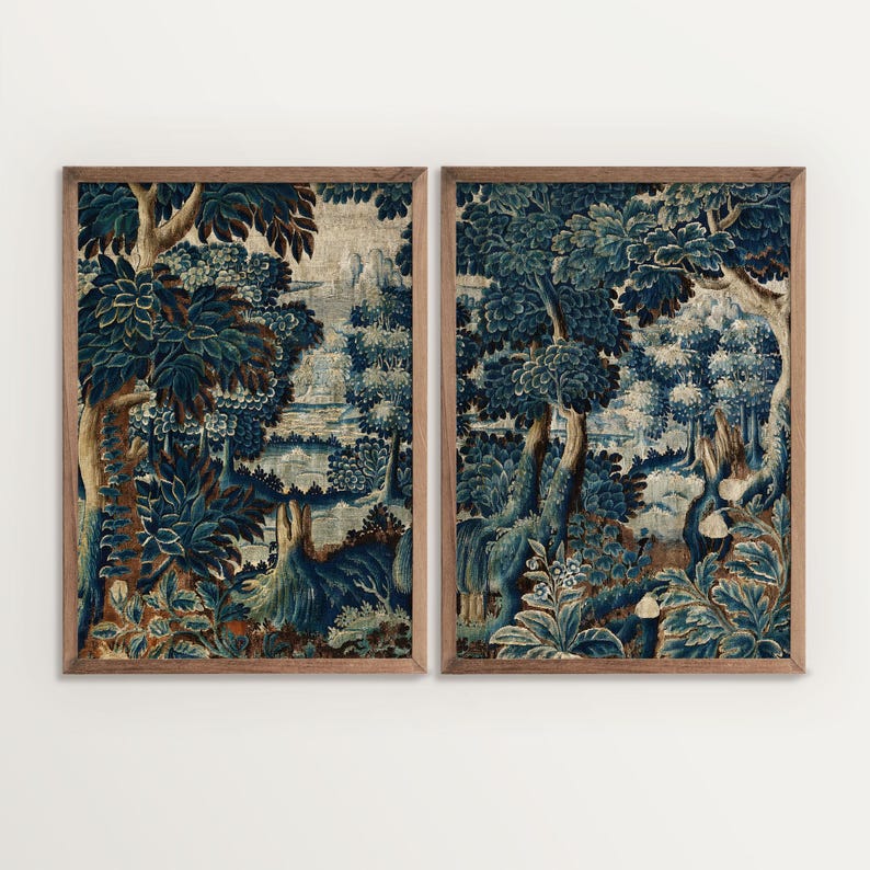 Two framed verdure tapestry prints with detailed blue foliage and soft aged tones are presented side by side. The coordinated diptych design highlights the rich botanical landscape and classic textile style of the wall art set.
