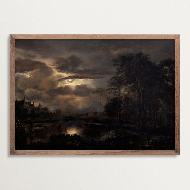 Framed dark landscape art print showing a dramatic night sky with glowing moonlight over clouds, trees, and a river, in a classic wooden frame.