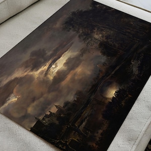 Unframed dark landscape art print lying flat on a beige sofa, showing moonlight breaking through dramatic clouds above a river and trees.