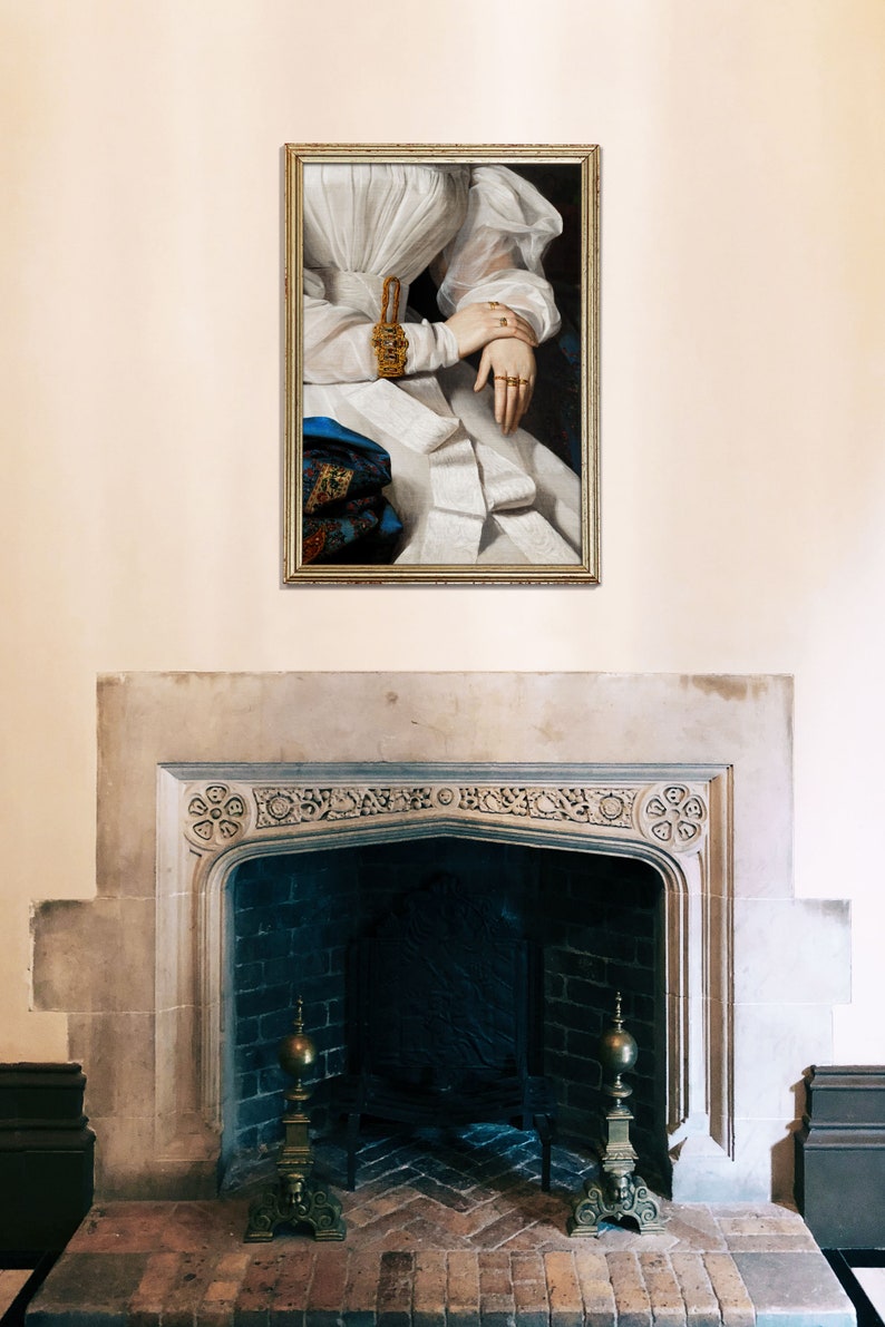 Antique fireplace above which hangs a golden frame showing detail of a victorian portrait of a woman wearing a white dress, golden rings and a golden bracelet with many gemstones.